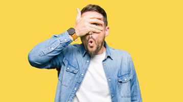 Hombre tímido tapándose la cara, simbolizando la vergüenza y la timidez al relacionarse