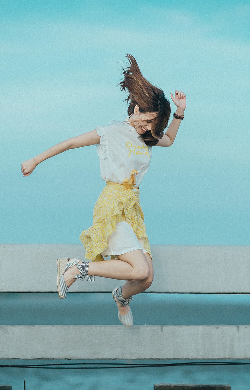 Mujer joven saltando con alegría, simbolizando la mejora del bienestar tras superar la ansiedad en terapia en Madrid