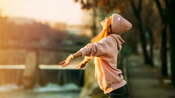 Mujer al aire libre con gesto de alivio y calma, imagen asociada a ansiedad digital y dificultad para desconectar