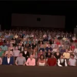 Auditorio virtual con público sentado, visto desde el escenario.
