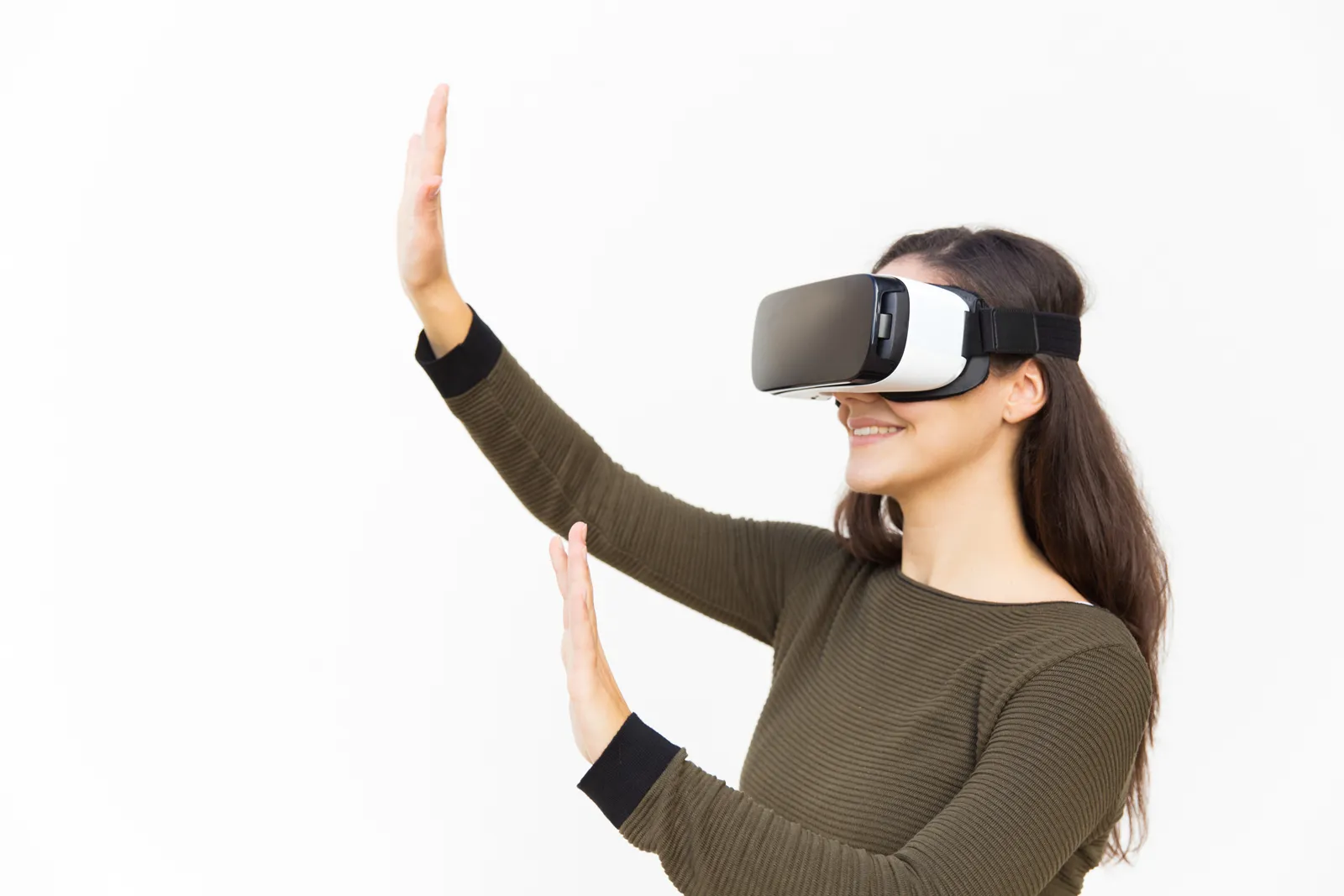 Mujer con gafas de realidad virtual y las manos levantadas sobre un fondo blanco.